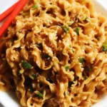 Chinese hand-pulled noodles tossed in chili oil, sesame, and scallions with red chopsticks