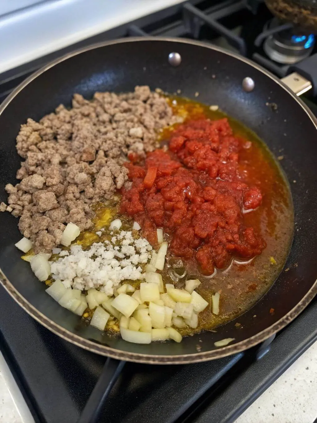 Prepare the Meat Sauce Ground meat, tomatoes, and onions cooking for Halloween pasta sauce