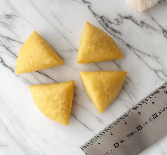 Roll 1 Four pieces of fresh pasta dough on marble surface with ruler