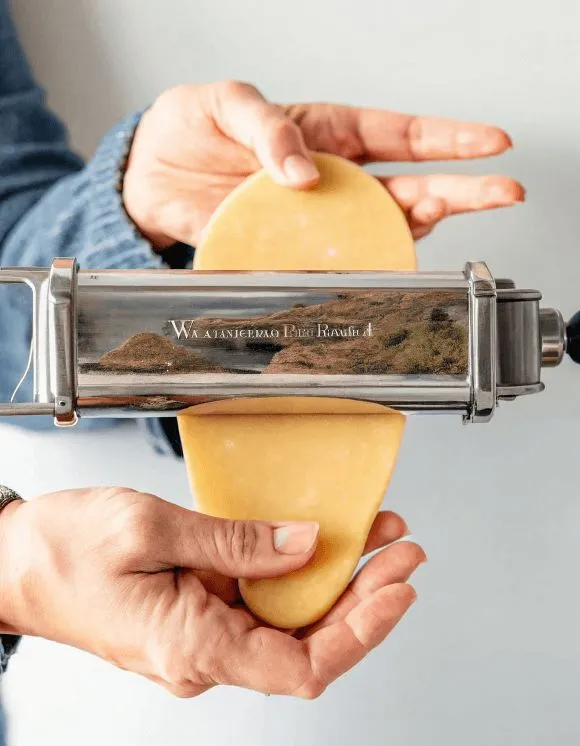 Roll 2 Person feeding pasta dough into a roller attachment
