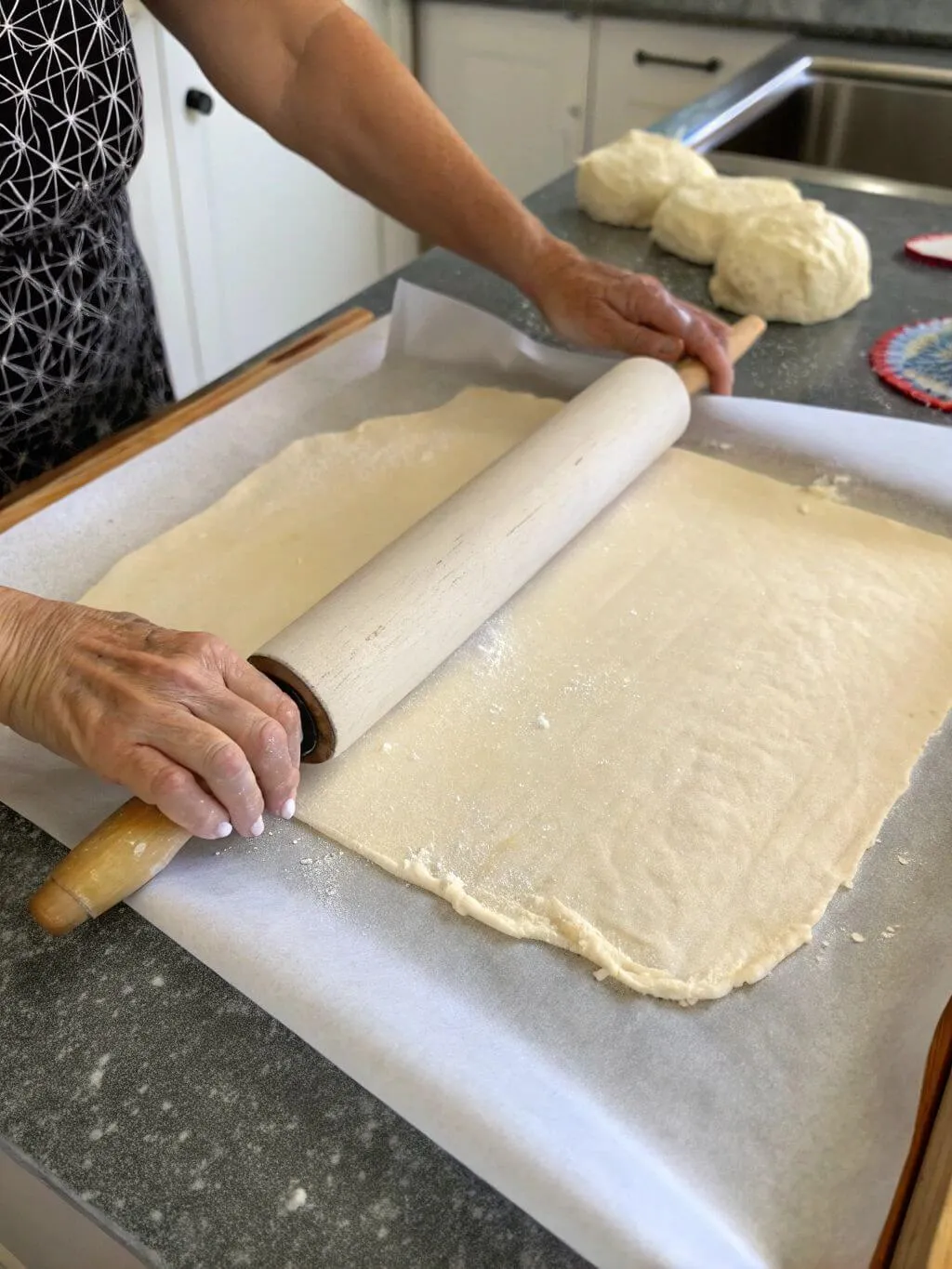 Roll Out Hands using rolling pin to flatten keto pasta dough on parchment