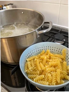 Rotini pasta boiling in pot and drained for Easy Antipasto Pasta Salad